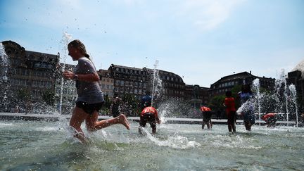 Des personnes se rafraîchissent dans une fontaine de Strasbourg (Bas-Rhin), le 22 juin 2017. (FREDERICK FLORIN / AFP)