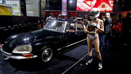 Une h&ocirc;tesse pose au c&ocirc;t&eacute; d'une&nbsp;Citro&euml;n DS vintage au Salon automobile de P&eacute;kin (Chine), le 23 avril 2012. (DIEGO AZUBEL / MAXPPP)