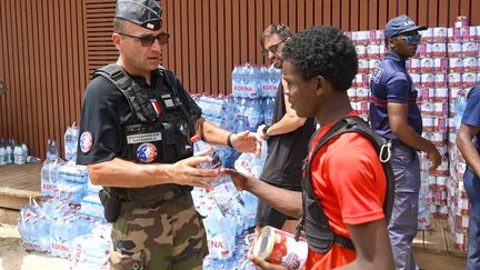 Un gendarme participe à une distribution d'aide alimentaire à Pamandzi (Mayotte), le 18 décembre 2024. (MINISTERE DE L'INTERIEUR / MAXPPP)