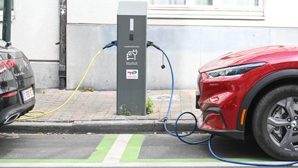 Une voiture électrique en train d'être rechargée à une borne, dans les rues de Bruxelles. (JEAN-LUC FLEMAL / MAXPPP)