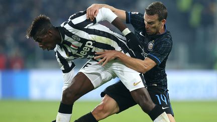 Paul Pogba au duel avec Hugo Armando Campagnaro (MARCO BERTORELLO / AFP)