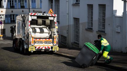 Un éboueur déplace des poubelles, le 16 avril 2020 à Paris. (illustration) (JOEL SAGET / AFP)