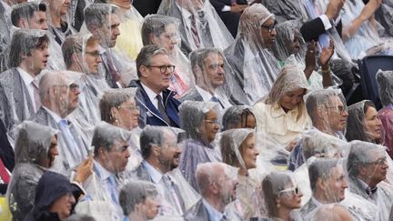 Si la pluie n'a pas gâché la fête, elle a obligé beaucoup de spectateurs à sortir l'imperméable. Le Premier ministre britannique Keir Starmer s'en est passé. (MUSTAFA CIFTCI / AFP)