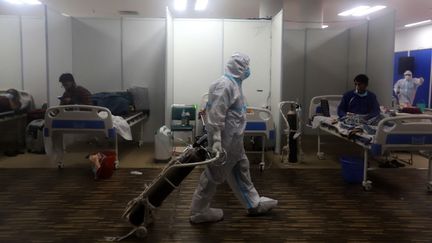 Un soignant s'occupe de patients atteints de Covid-19 dans un hôpital de New Delhi, en Inde, le 23 avril 2021. (AMARJEET KUMAR SINGH / ANADOLU AGENCY / AFP)