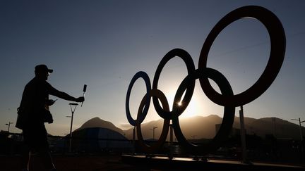 Un journaliste photographie les anneaux olympiques à Rio de Janeiro (Brésil), le 31 juillet 2016. (CHRISTIAN PETERSEN / GETTY IMAGES NORTH AMERICA / AFP)