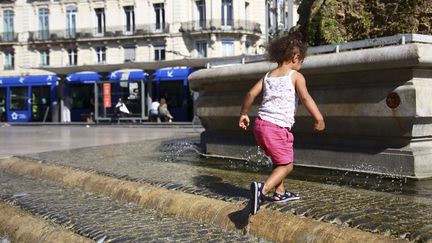 Une enfant se rafraîchit dans une fontaine, place de la Comédie à Montpellier (Hérault), le 17 juin 2018. (LODI FRANCK/SIPA)