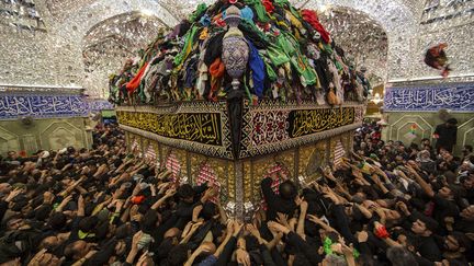 Des p&eacute;lerins musulmans chiites se pressent pour toucher le tombeau de l'imam&nbsp;Abbas ibn Ali &agrave; Kerbala (Irak), le 13 d&eacute;cembre 2014. (REUTERS)