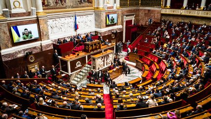 Les députés réunis dans l'hémicycle de l'Assemblée nationale, le 23 mars 2022, à l'occasion de l'intervention du président ukrainien&nbsp;Volodymyr Zelensky en visioconférence. (XOSE BOUZAS / HANS LUCAS / AFP)