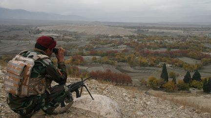 Un soldat de l'armée afghane surveille une zone d'où 9 000 familles ont fui à cause des combats entre l'Etat islamique et les talibans, le 28 novembre 2017, à Hogyani (Afghanistan). (ZABIHULLAH GHAZI / AFP)