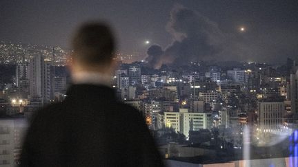 Un Libanais regarde la fumée s'élever après une frappe israélienne sur le quartier de Dahieh à Beyrouth, le 21 octobre 2024. Photo d'illustration. (MURAT SENGUL / ANADOLU / VIA AFP)