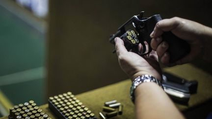 Un homme prépare son arme au club de tir "Calibre 12" à Sao Goncalo, à Rio de Janeiro, au Brésil, le 3 septembre 2018.&nbsp; (DANIEL RAMALHO / AFP)