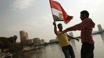 De jeunes égyptiens brandissent le drapeau national trois jours après la démission d'Hosni Moubarak (14/02/2011) (AFP - Mohammmed Abed)