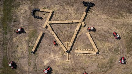 Vue aérienne du 23 juin 2022 par un drone, montrant des tracteurs et des bottes de foin dessinant un vélo, une sculture de "land art"&nbsp;au bord&nbsp;de la route à Jutland, au Danemark.
 (MADS CLAUS RASMUSSEN / RITZAU SCANPIX / AFP)