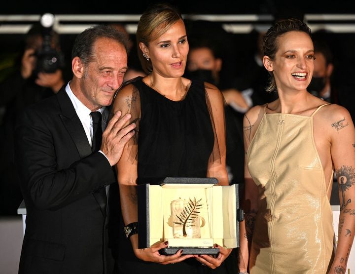 La réalidatrice française Julia Ducournau pause avec sa Palme d'or pour "Titane", entourée de son acteur Vincent Lindon et de son actrice Agathe Rousselle, au 74e festival de Cannes (2021). (MUSTAFA YALCIN / ANADOLU AGENCY)