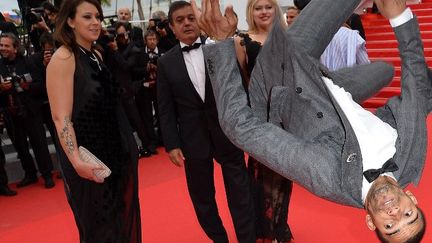 Le tapis rouge la tête en bas, c'est comment ? Le danseur Brahim Zaibat a une façon bien à lui de monter les marches...
 (ALBERTO PIZZOLI / AFP)