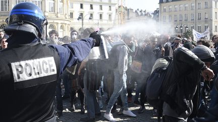 Un policier aspergeant des jeunes manifestants à Rennes (Ille-et-Vilaine), le 17 mars 2016. (DAMIEN MEYER / AFP)