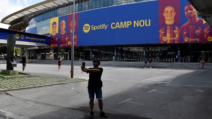 Un homme se prend en photo devant l'entrée du Camp Nou, stade de Barcelone (Espagne). (PAU BARRENA / AFP)