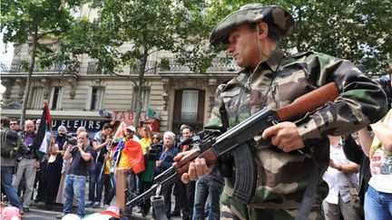 &nbsp; (Un homme avec une kalachnikov qui semble réelle lors de la manifestation pro-Gaza © RF-Nathanaël Charbonnier)