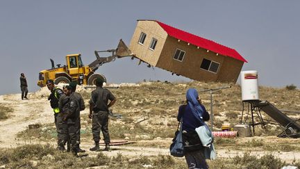 Des policiers des fronti&egrave;res isra&eacute;liens supervisent la destruction d'une maison en pr&eacute;fabriqu&eacute; dans une colonie juive de Cisjordanie pr&egrave;s de Bethl&eacute;em (Palestine), le 14 mai 2014. (RONEN ZVULUN / REUTERS)