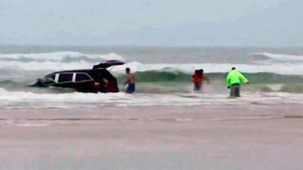 Capture d'&eacute;cran d'une vid&eacute;o montrant une voiture s'enfon&ccedil;ant dans l'eau avec une femme et ses trois enfants &agrave; bord, en Floride, le 4 mars 2014. (SIMON BESNER/AP/SIPA / AP)