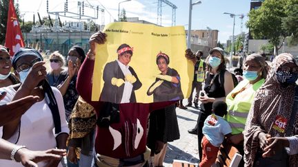 Des&nbsp;grévistes de l'hôtel Ibis Batignolles manifestent&nbsp;devant le siège social du groupe Accor, le 8 septembre 2020. Une des participantes brandit une affiche avec les deux porte-parole du mouvement : Rachel Keke et&nbsp;Sylvie Kimissa Esper. (BRUNO LEVESQUE / MAXPPP)