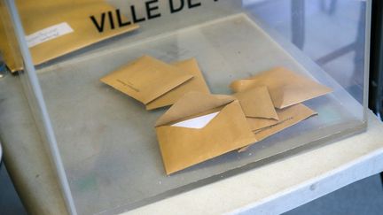 Une urne avec quelques bulletins de vote lors du 1er tour des élections municipales, le 15 mars 2020 à Valence. (NICOLAS GUYONNET / HANS LUCAS / AFP)