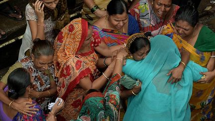 Des habitants pleurent la perte de proches apr&egrave;s l'effondrement d'un immeuble &agrave; Bombay (Inde), le 28 septembre 2013. (PUNIT PARANJPE / AFP)