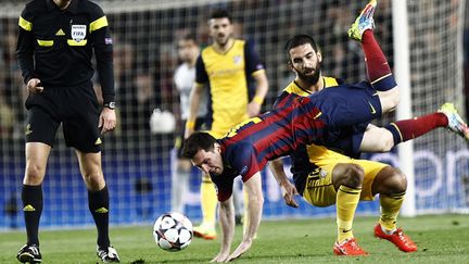 Lionel Messi chahuté par Arda Turan (QUIQUE GARCIA / AFP)