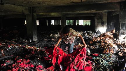 Un ouvrier au milieu des d&eacute;combres d'une usine textile apr&egrave;s un incendie le 9 mai 2013 dans la banlieue de Dacca au Bangladesh.&nbsp; (MUNIR UZ ZAMAN / AFP)