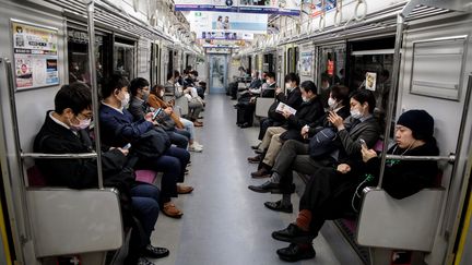 Des Japonais portant des masques dans le métro de Tokyo, le 6 avril 2020. (BEHROUZ MEHRI / AFP)