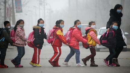 Des enfants avec leur institutrice, le 24 décembre 2015 à Jinan, dans la province du&nbsp;Shandong. (CHEN NING / IMAGINECHINA / AFP)