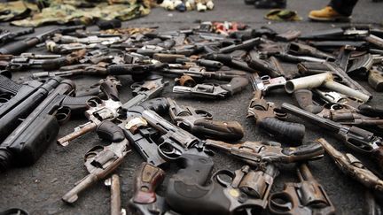 Des armes sont d&eacute;pos&eacute;es par des membres de gangs rivaux &agrave; San Salvador (Salvador) dans le cadre d'un tr&ecirc;ve sign&eacute;e en mars 2012, le 27 mai 2013. (REUTERS)