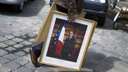 Un employ&eacute; retire le portrait de Nicolas Sarkozy du palais de l'Elys&eacute;e, le 15 mai 2012 &agrave; Paris. (THIBAULT CAMUS / AP / SIPA / AP)