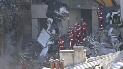 Des pompiers à la recherche des personnes disparues dans les décombres rue de Tivoli, à Marseille, le 9 avril 2023. (CLEMENT MAHOUDEAU / AFP)