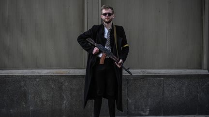 Sviatoslav&nbsp;Yurash, 26 ans, plus jeune député d'Ukraine, pose avec son fusil d'assaut alors qu'il patrouille dans le centre-ville de Kiev, le 27 février 2022. (ARIS MESSINIS / AFP)