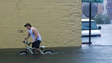 Les inondations provoqu&eacute;es par la temp&ecirc;te Debby ont trnasform&eacute; le d&eacute;placement de certains habitants de Live Oak (Floride) en v&eacute;ritable s&eacute;ance d'aquabike, le 26 juin 2012. (PHIL SEARS / REUTERS)