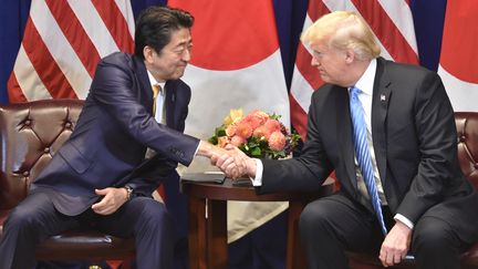 Le Premier ministre japonais Shinzo Abe (gauche) et le président américain Donald Trump se saluent en marge de l'Assemblée générale de l'ONU, à New York (Etats-Unis), le 26 septembre 2018. (NICHOLAS KAMM / AFP)