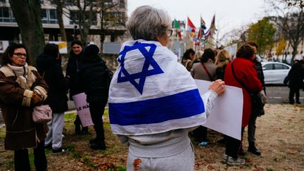 A Paris le 1er décembre 2023, une femme manifeste devant le siège de l'UNESCO pour dénoncer "le silence des organisations féministes internationales" face aux viols de masse commis le 7 octobre en Israël. Son jogging taché de sang imite celui d'une jeune israélienne capturée et filmée dans cet état par le Hamas.
. (DIMITAR DILKOFF / AFP)