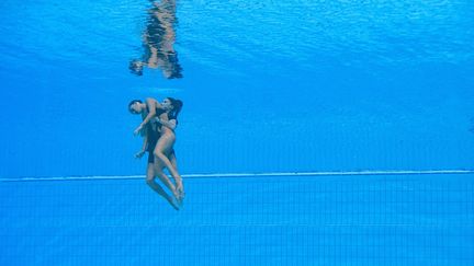 L'Américaine Anita Alvarez est secourue par son entraîneure, Andrea Fuentes, aux Mondiaux de Budapest (Hongrie), le 22 juin 2022. (OLI SCARFF / AFP) (OLI SCARFF / AFP)