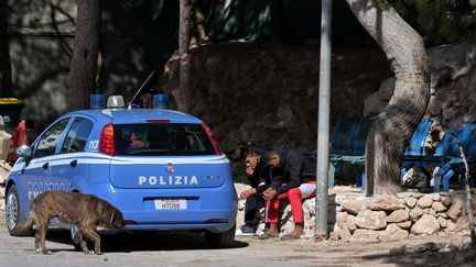 Des jeunes migrants patientent à l'extérieur d'un centre d'accueil de Lampedusa, en septembre 2023. (TIZIANA FABI / AFP)