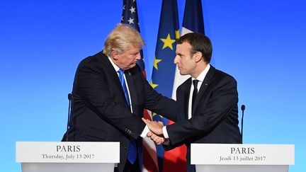 Six Français sur dix approuvent la décision d'Emmanuel Macron d'inviter Donald Trump pour les cérémonies du 14-Juillet à Paris. (ALAIN JOCARD / AFP)