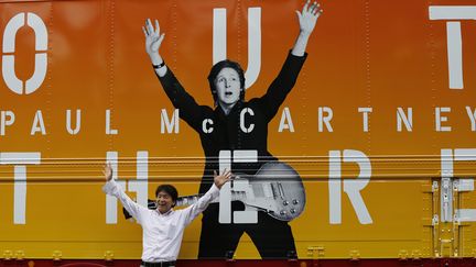 &nbsp; (Un fan de Paul McCartney devant l'affiche de la tournée du chanteur au Japon © Reuters-Issei Kato)