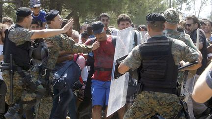 Certains affrontements entre migrants et forces de l'ordre arrivent comme en Mac&eacute;doine le 24 ao&ucirc;t 2015. La police essaie d'arr&ecirc;ter un groupe de migrants qui tentent d'atteindre la gare de Gevgelija, une &eacute;tape vers l'entr&eacute;e en Union europ&eacute;enne. (BORIS GRDANOSKI/AP/SIPA)