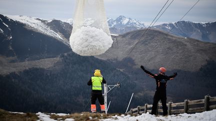 Un hélicoptère largue de la neige à la station Superbagnères (Haute-Garonne), le 15 février 2020. (ANNE-CHRISTINE POUJOULAT / AFP)