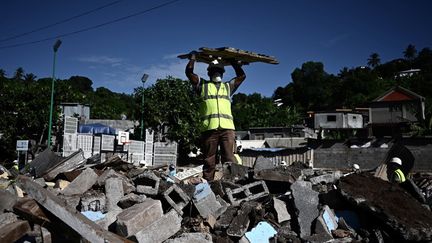 Un employé chargé de la démolition du bidonville "Talus 2" dans le district de Koungou à Mayotte le 22 mai 2023 (PHILIPPE LOPEZ / AFP)