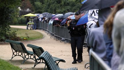 Un policier patrouille le long de la file d'attente pour la visite du palais de l'Elysée à l'occasion des Journées du patrimoine le 17 septembre 2016 à Paris. (FRANCOIS GUILLOT / AFP)