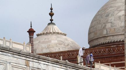 Le 30 mai, des ouvriers constatent les dégâts causés par la grosse tempête de la région d'Agra notamment sur les balustrades sur le toit du Taj Mahal. (PAWAN SHARMA / AFP)