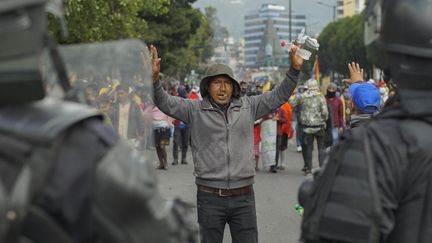 Un manifestant fait face à des policiers à Quito, en Equateur, le 22 juin 2022. (VERONICA LOMBEIDA / AFP)