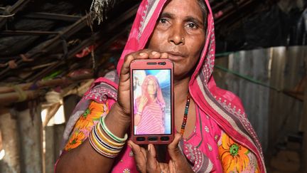 Mohinidevi Nath montre une photo de sa cousine Shantadevi Nath, lynchée après la diffusion d'une rumeur sur les réseaux sociaux en juin 2018. (SAM PANTHAKY / AFP)