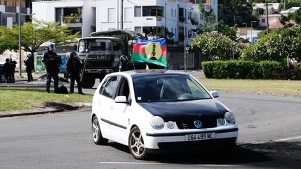 Une voiture arborant le drapeau du Front de libération nationale kanak socialiste (FLNKS) lors de manifestations liées au débat sur le projet de loi constitutionnel, à Nouméa le 14 mai 2024. (THEO ROUBY / AFP)